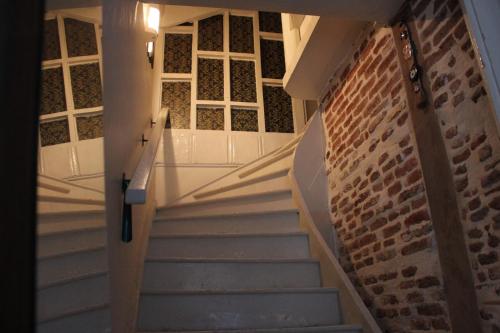 a staircase in a house with a brick wall at Macide Hanım Konağı in Ayvalık