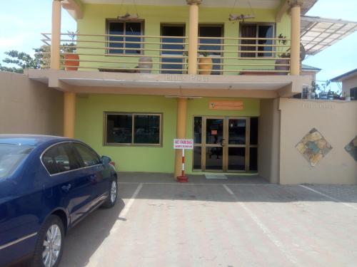 a car parked in front of a building with a balcony at Feehi's Place in Accra
