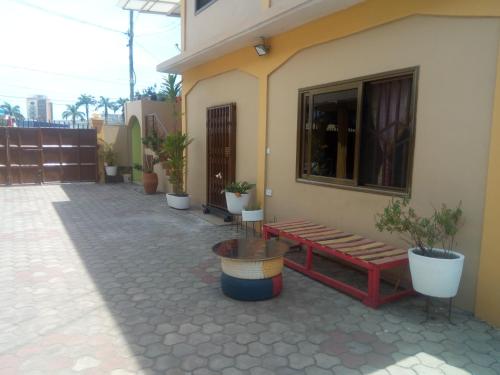 a bench on the side of a building with potted plants at Feehi's Place in Accra