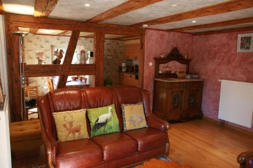 un salon avec un canapé en cuir et une table dans l'établissement Gîte Schlitteur Et Sapiniere, à Breitenbach