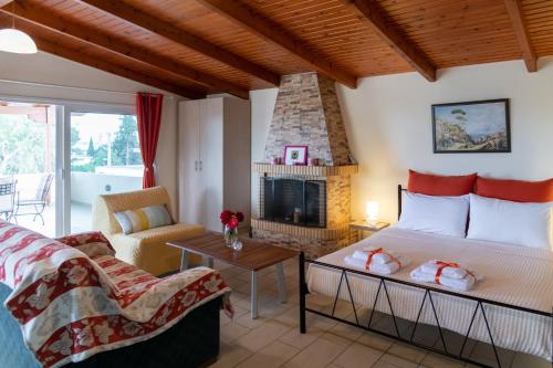 a living room with a bed and a fireplace at Rose's House (Near Airport) in Artemida