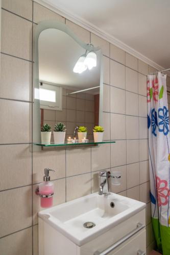 a bathroom with a sink and a mirror at Rose's House (Near Airport) in Artemida