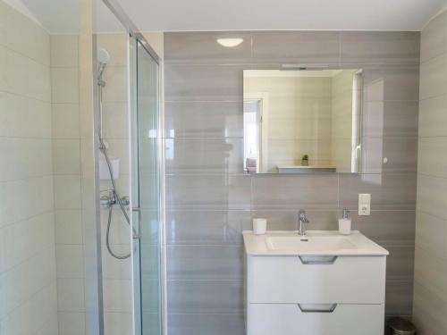 a white bathroom with a sink and a shower at Apartmani Ticinovic in Omiš