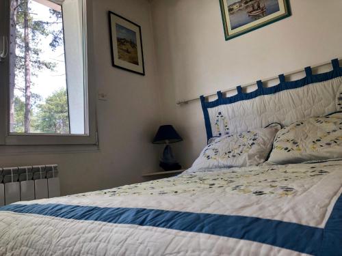 - une chambre avec un lit doté d'une tête de lit bleue et d'une fenêtre dans l'établissement Maison Sapinettes, à Quend