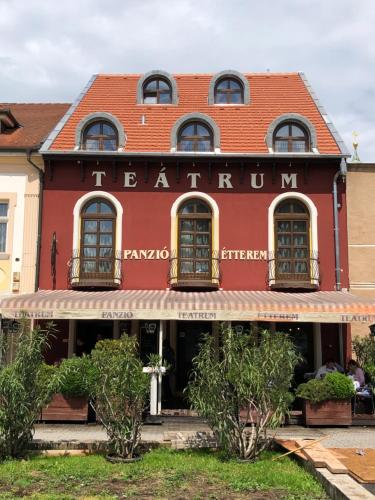 a red building with a sign that reads herkun at Teátrum Boutique Hotel in Győr