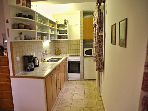 a kitchen with wooden cabinets and a white refrigerator at Chalupa Ivana Bozkov in Bozkov
