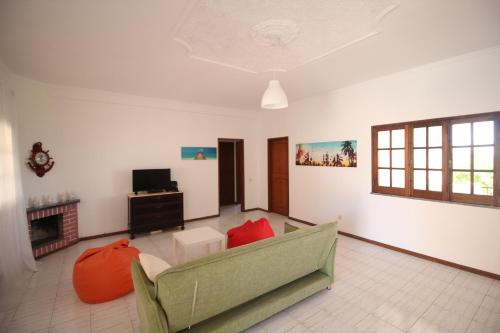 a living room with a couch and a television at White Bride FZ in Fuzeta