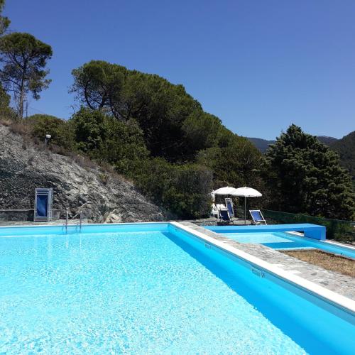 a swimming pool with a mountain in the background at Elegant and Sea View Excelsior Apartment in Levanto