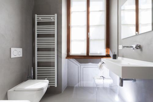 a bathroom with a white toilet and a sink at Casa Alla Lega in Arco