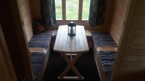 a wooden table in a room with a window at Gaišie in Jūrmalciems