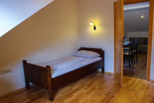 a small bed in a room with a staircase at Kmetija Na Čendavš in Cerkno