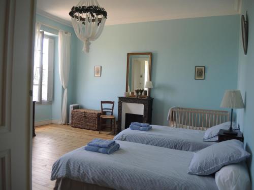 two beds in a room with blue walls at Château Mauras in Bommes