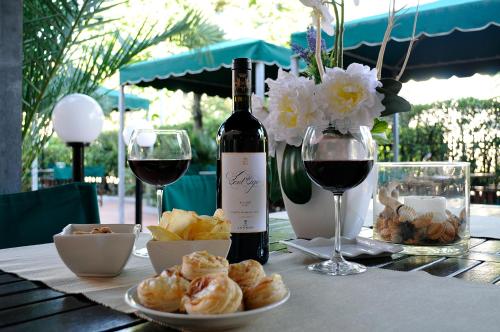 a table with a bottle of wine and a plate of bread at Hotel Liu in Lido di Camaiore