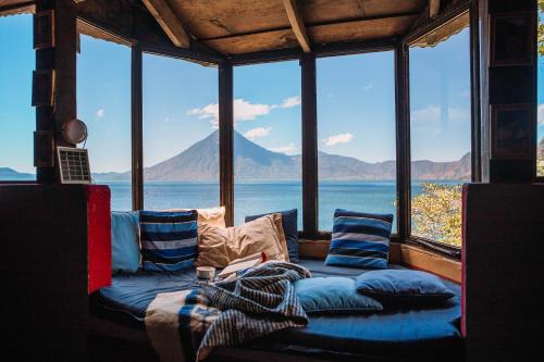 a living room with a couch in front of a large window at Atitlan Sunset Lodge in Santa Cruz La Laguna