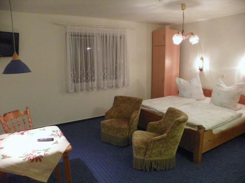 a hotel room with a bed and two chairs at Gemütlich privat allergiearm in Timmendorfer Strand