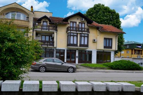 a car parked in front of a house at Riverside apartment #1. View over Fortress Kastel in Banja Luka