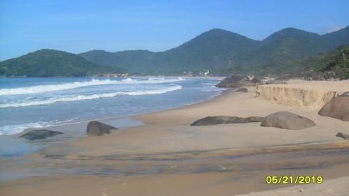 a beach with rocks in the sand and the ocean at Pousada Marimbá in Trindade