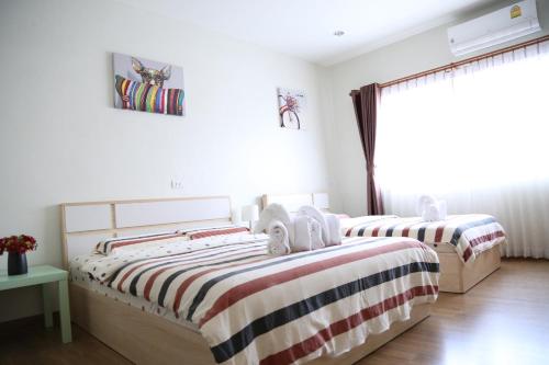 two beds in a white room with a window at TD Bangkok in Bangkok