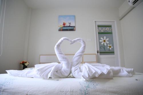 two white swans making a heart on a bed at TD Bangkok in Bangkok