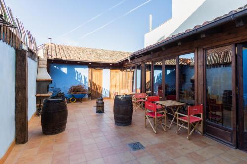 a patio with red chairs and tables and windows at La Casa Azul in Alcanadre