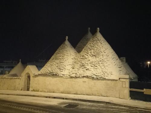 a building covered in snow at night at B&b I Trulli dei Desideri in Alberobello