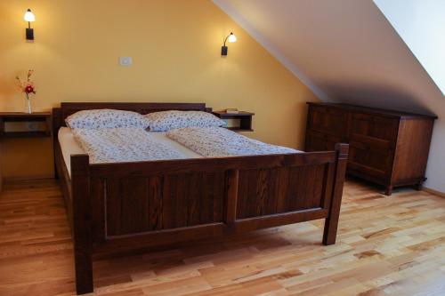 een slaapkamer met een houten bed op zolder bij Kmetija Na Čendavš in Cerkno