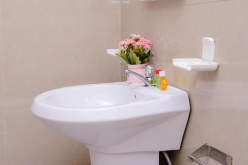 a bathroom with a sink and a toilet with flowers on it at Homestay Garden Rest Kandy in Kandy