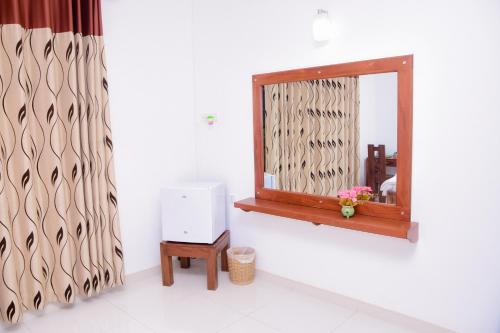 a mirror in a room with a table and a window at Homestay Garden Rest Kandy in Kandy