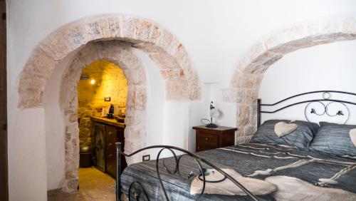 a bedroom with a bed in a stone archway at B&b I Trulli dei Desideri in Alberobello