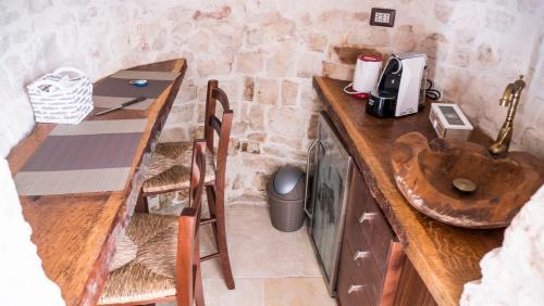 a kitchen with a wooden table and a sink at B&b I Trulli dei Desideri in Alberobello