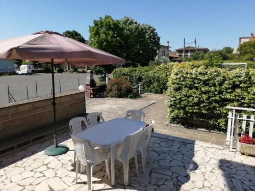 a table and chairs under an umbrella on a patio at Appartamento in centro paese in Monterosi