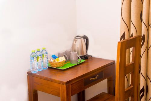 a table with a coffee maker and water bottles on it at Homestay Garden Rest Kandy in Kandy