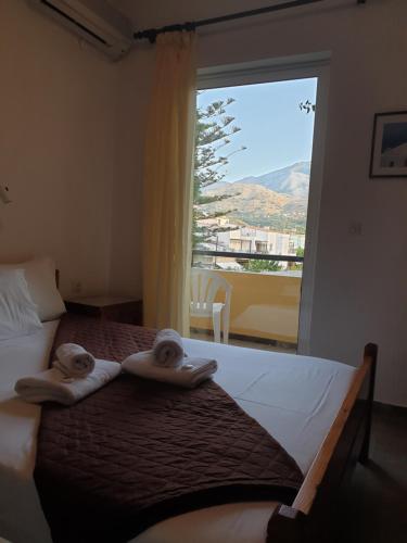 1 dormitorio con 1 cama con toallas y ventana en Drosia Hotel en Georgioupolis