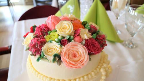 a cake with flowers on top of it on a table at Vänerport Lakefront Hotell in Mariestad