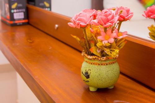 a vase filled with pink flowers sitting on a counter at Homestay Garden Rest Kandy in Kandy