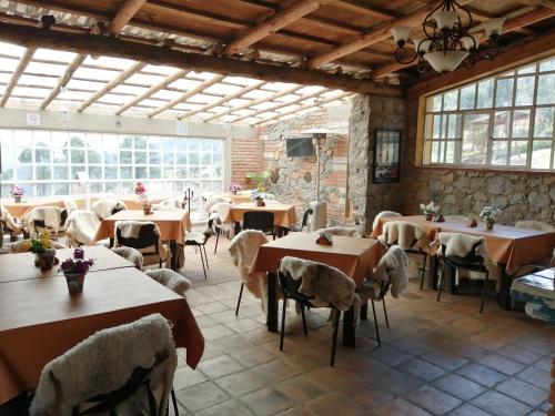 een restaurant met tafels en stoelen in een kamer bij Rancho Escondido Casa Goyri in Tlaxco de Morelos
