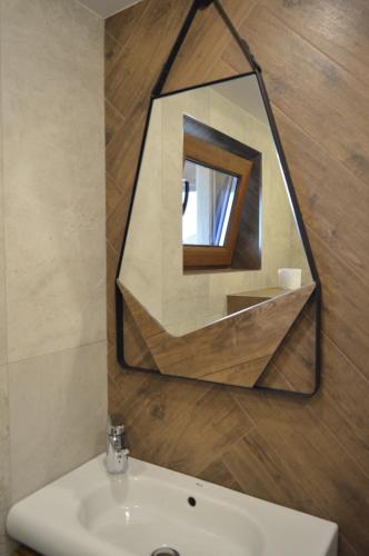 a mirror above a sink in a bathroom at Apartments Dona in Chernomorets