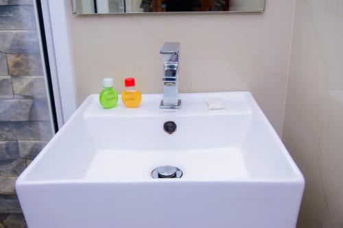 a white bathroom sink with two bottles on it at Homestay Garden Rest Kandy in Kandy