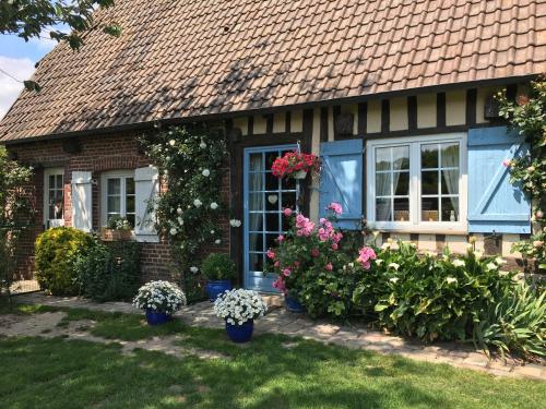 une maison avec des fleurs et des plantes dans la cour dans l'établissement Chambre meublée 