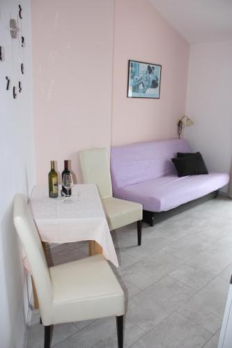 a room with a table and a bed and a table and chairs at Guesthouse Santor in Lastovo