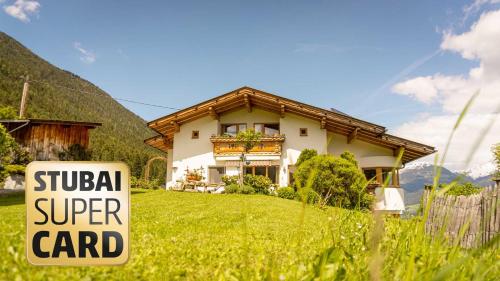 a sign in the grass in front of a house at Stubaier Bauern Appartement in Telfes im Stubai