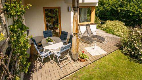a wooden deck with a table and chairs on it at Stubaier Bauern Appartement in Telfes im Stubai