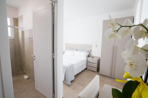 - une chambre avec un lit blanc et un miroir dans l'établissement Villa Milù, à Torre San Giovanni