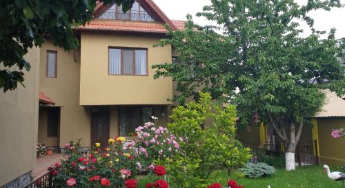 una casa con un mazzo di fiori davanti di Villa Mugur a 2 Mai
