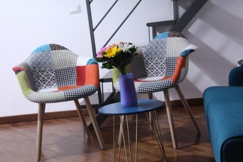 trois chaises avec un vase bleu et des fleurs en elles dans l'établissement Casa PAN (Percorso Arabo Normanno), à Palerme