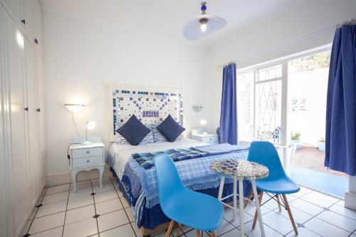 a bedroom with a blue bed and blue chairs at A Heavenly View in Muizenberg