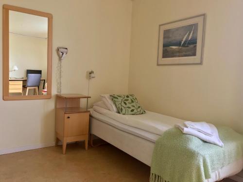 a small bedroom with a bed and a mirror at STF Malmfältens Folkhögskola in Kiruna