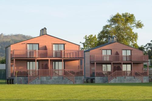 two houses with balconies on them in a field at Cabanas Da Barcela in Barreiros