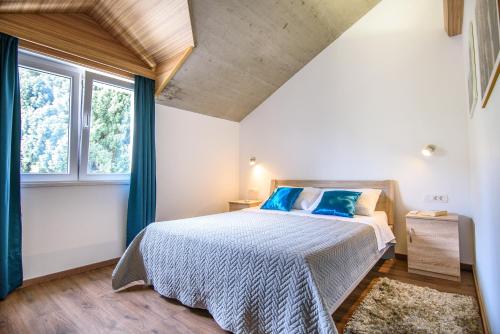 a bedroom with a bed and two windows at California Apartments 3 in Dubrovnik