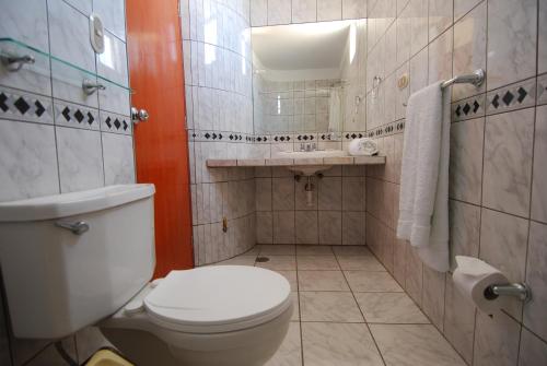 uma casa de banho com um WC, um lavatório e um espelho. em Hotel Alegria Nasca em Nazca